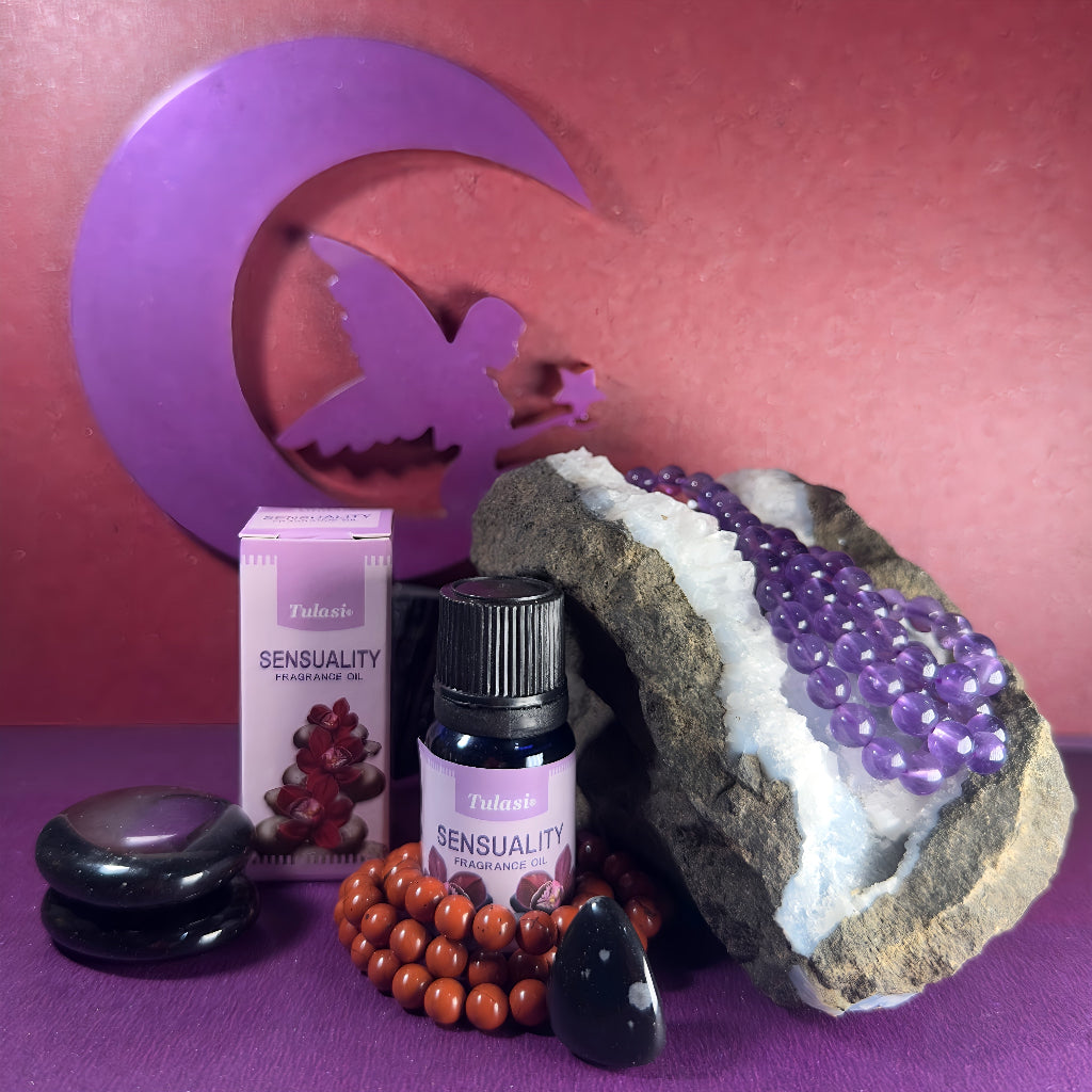 Flacon et boîte d'huile parfumée Tulasi Sensualité, entourés de pierres naturelles et d’une géode d’améthyste, ambiance mystique et apaisante.