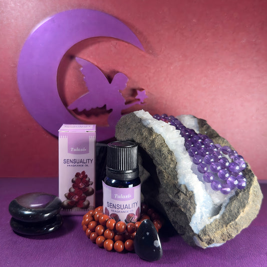 Flacon et boîte d'huile parfumée Tulasi Sensualité, entourés de pierres naturelles et d’une géode d’améthyste, ambiance mystique et apaisante.